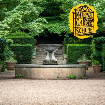 Formal garden with stone fountain, surrounded by manicured greenery and trees, with National Garden Scheme logo in the corner.