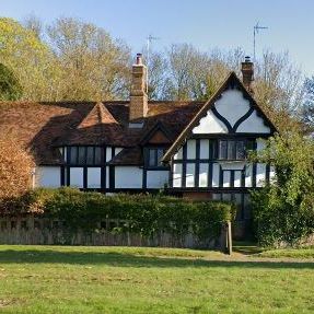 Traditional English cottage with timber framing and lush garden surroundings