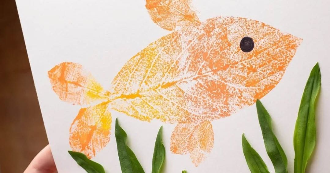 Leaf art goldfish with green leaf seaweed on white paper