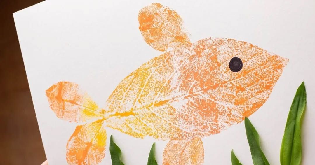 Leaf art goldfish with green leaf seaweed on white paper