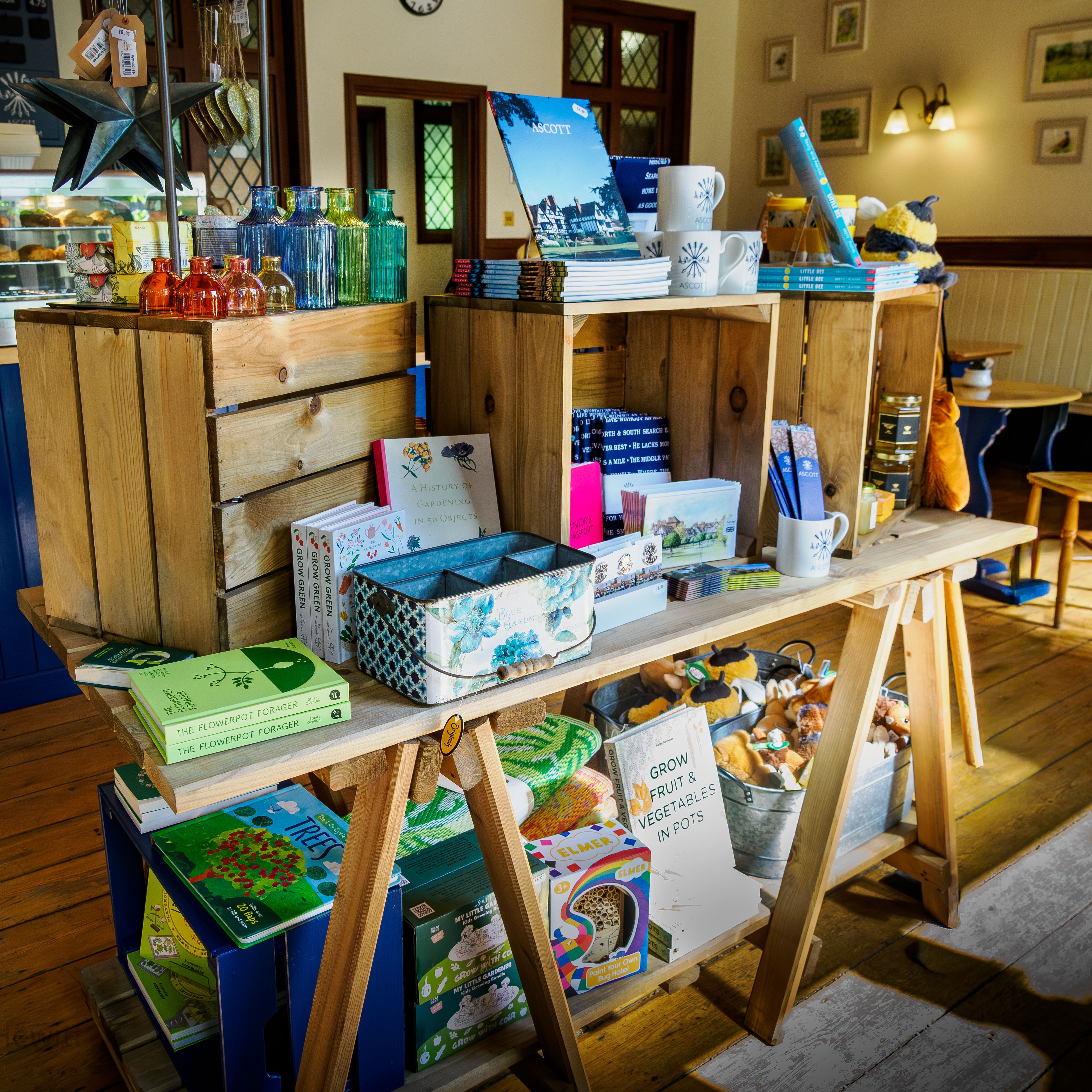 Display table of colourful glass bottles, books and souvenirs in a cosy café shop interior