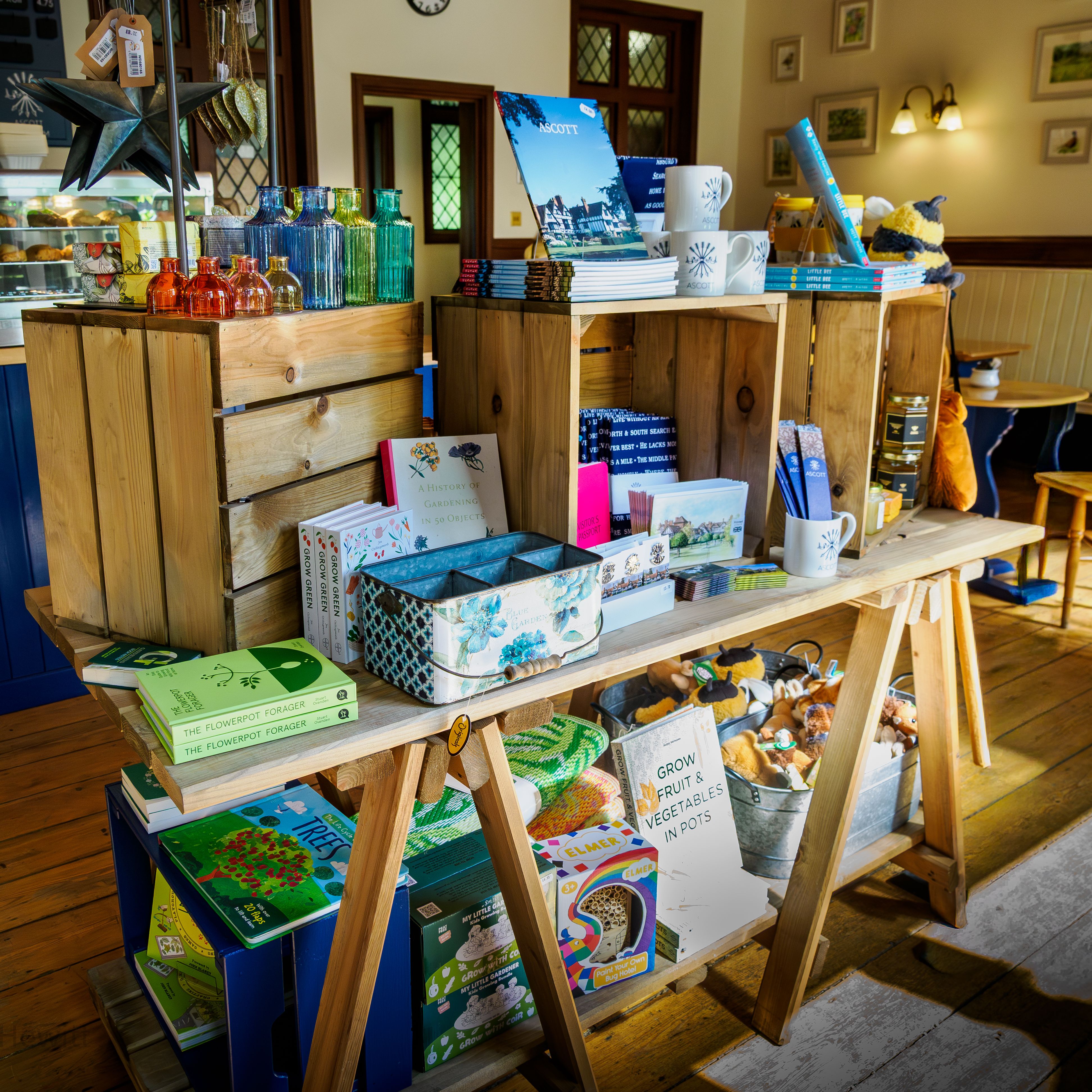 Display table of colourful glass bottles, books and souvenirs in a cosy café shop interior
