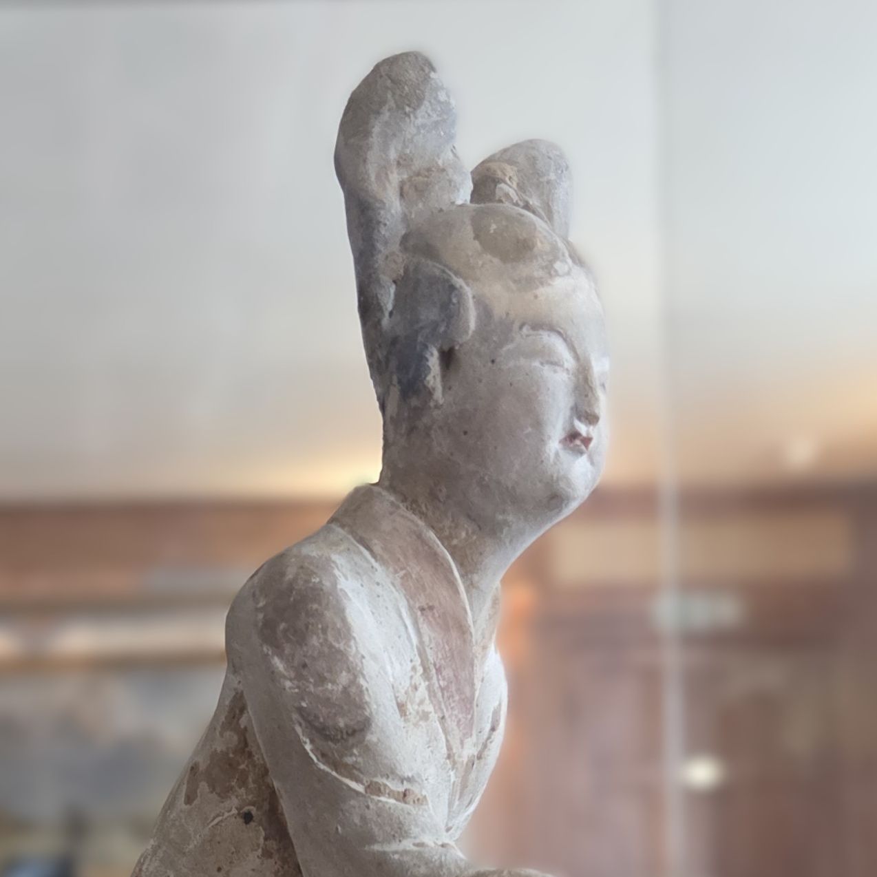 T'ang dynasty dancing girl figurine displayed in a glass museum case