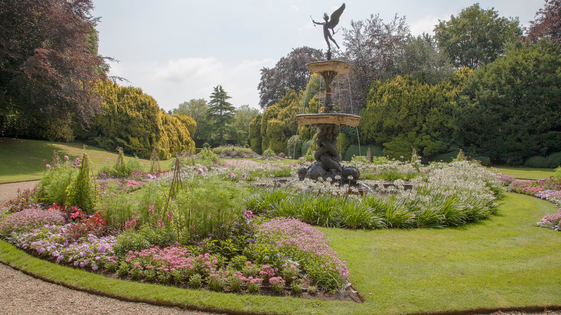 Garden with a large decorative fountain and colorful flower beds