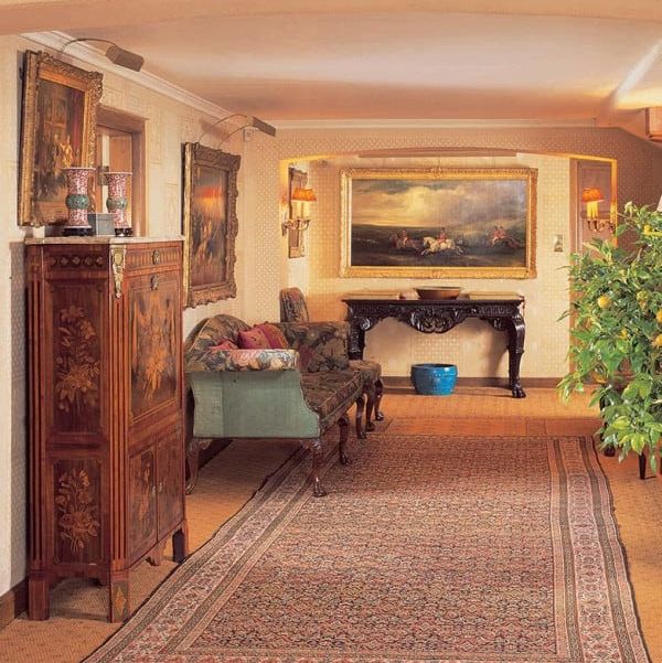 Elegant historic house interior with antique furniture, artwork, and a Persian rug