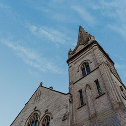 Stone church tower with arched windows against a blue sky