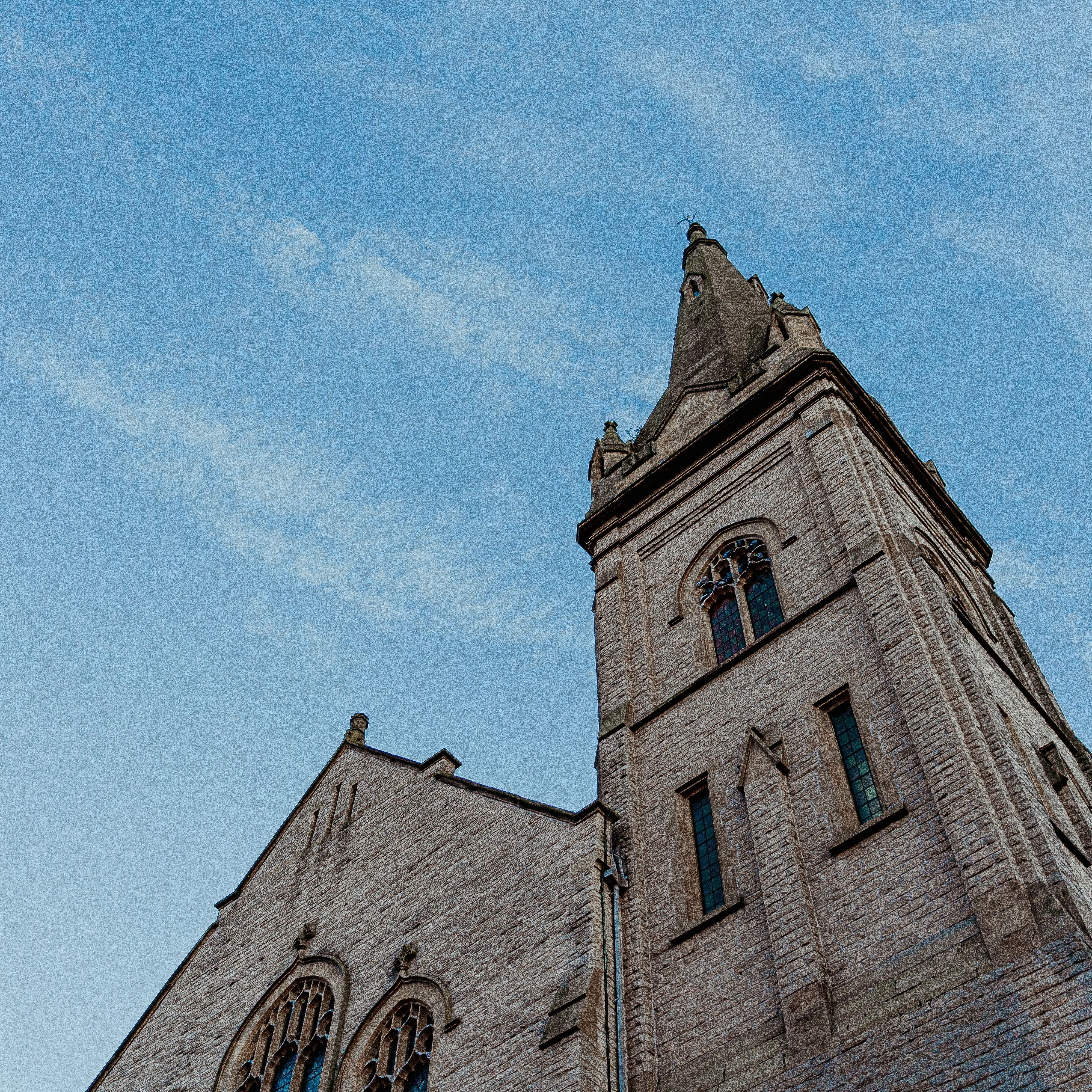 Stone church tower with arched windows against a blue sky