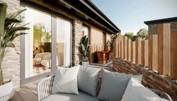 Luxury suite with stone walls, outdoor seating area, potted plants, and a copper bathtub on a private terrace