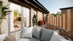 Luxury suite with stone walls, outdoor seating area, potted plants, and a copper bathtub on a private terrace