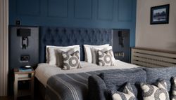 Aysgarth Falls Hotel Room with a king-sized bed, comfortable bedding and blue panel walls with a sofa at the end of the bed