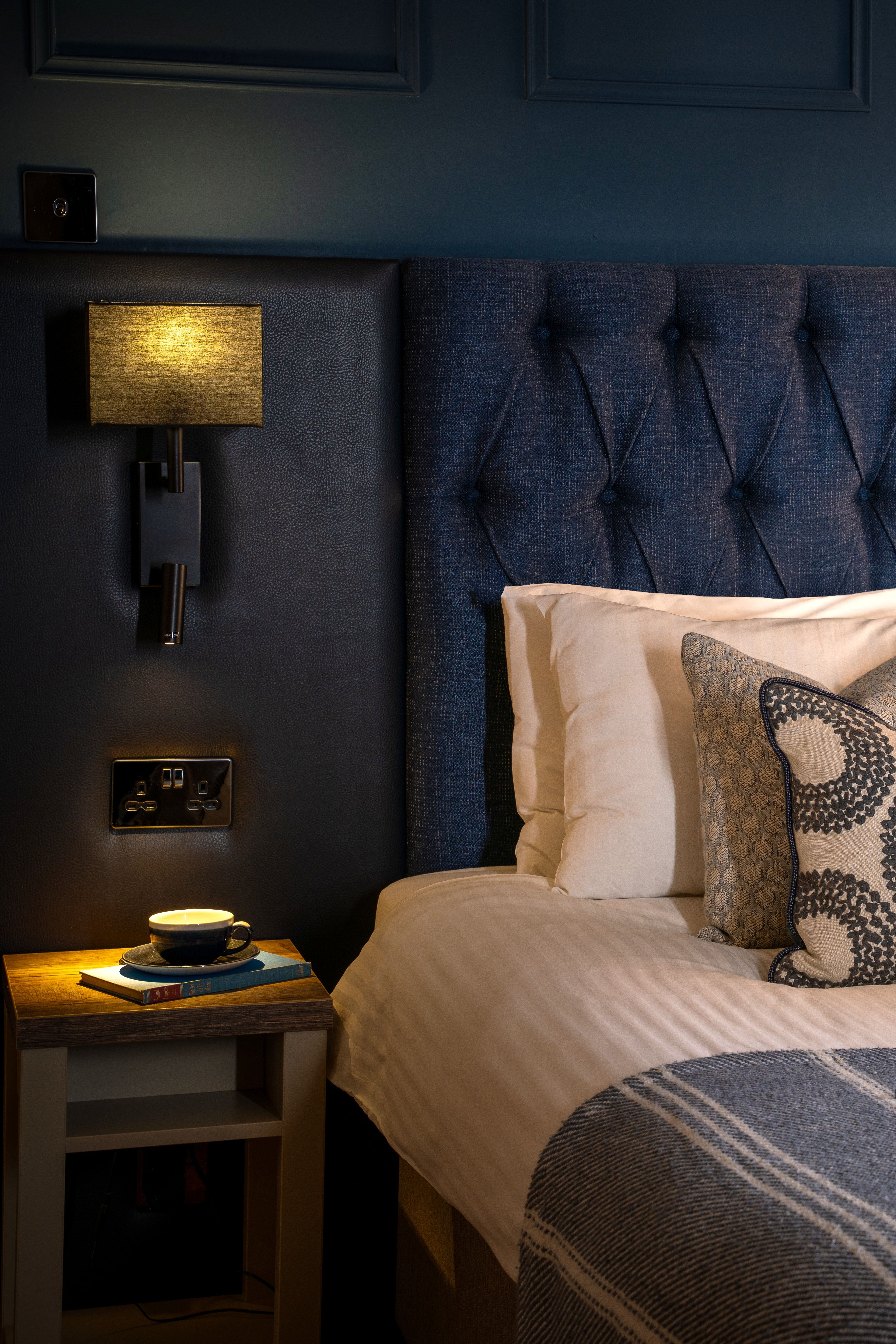 Aysgarth Falls Hotel Room with a king-sized bed, comfortable bedding and blue panel walls with a sofa at the end of the bed