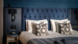 Aysgarth Falls Hotel Room with a king-sized bed, comfortable bedding and blue panel walls with a sofa at the end of the bed