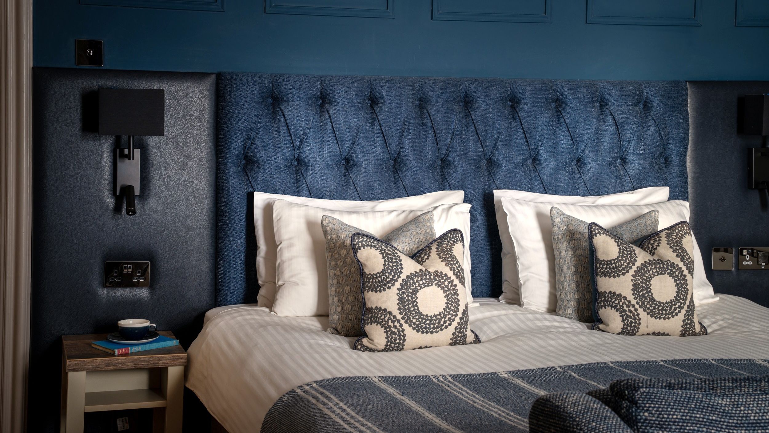 Aysgarth Falls Hotel Room with a king-sized bed, comfortable bedding and blue panel walls with a sofa at the end of the bed