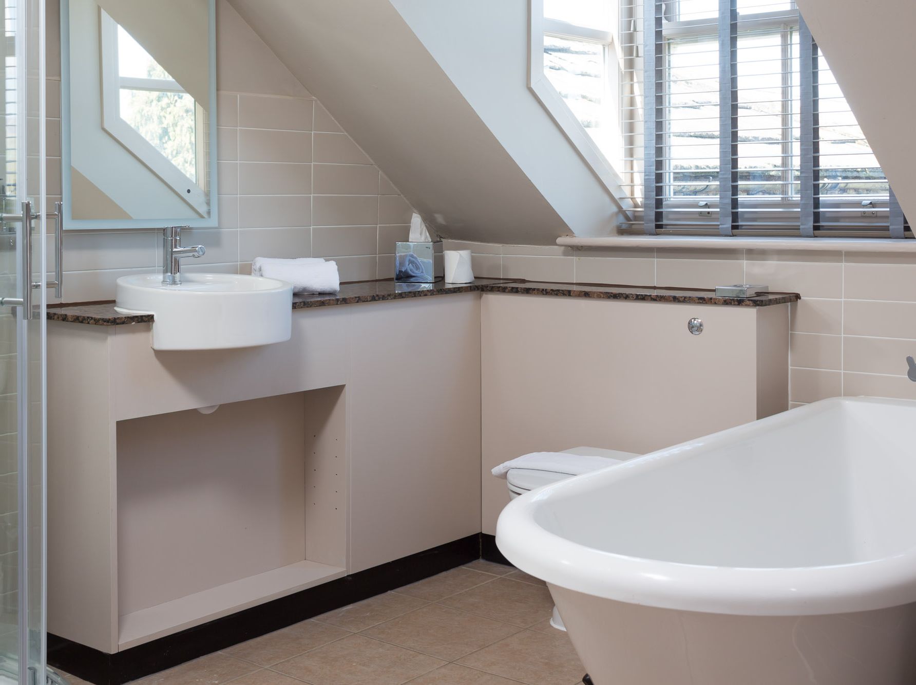 Modern bathroom with bathtub, sink, and window