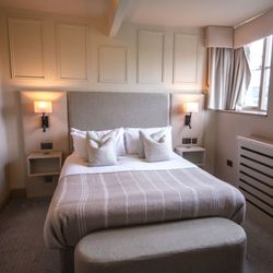 Cozy modern hotel bedroom with double bed and large windows