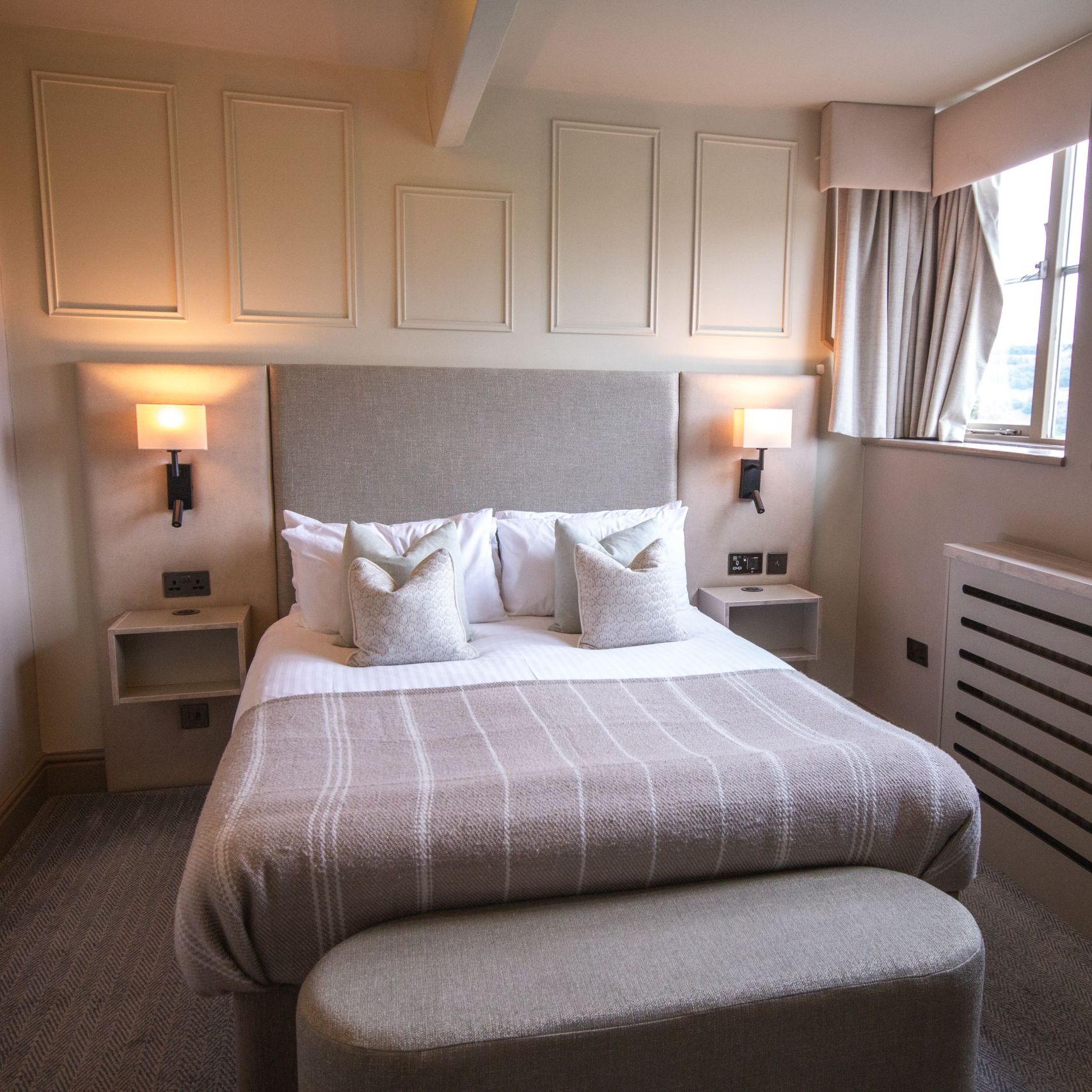 Cozy modern hotel bedroom with double bed and large windows