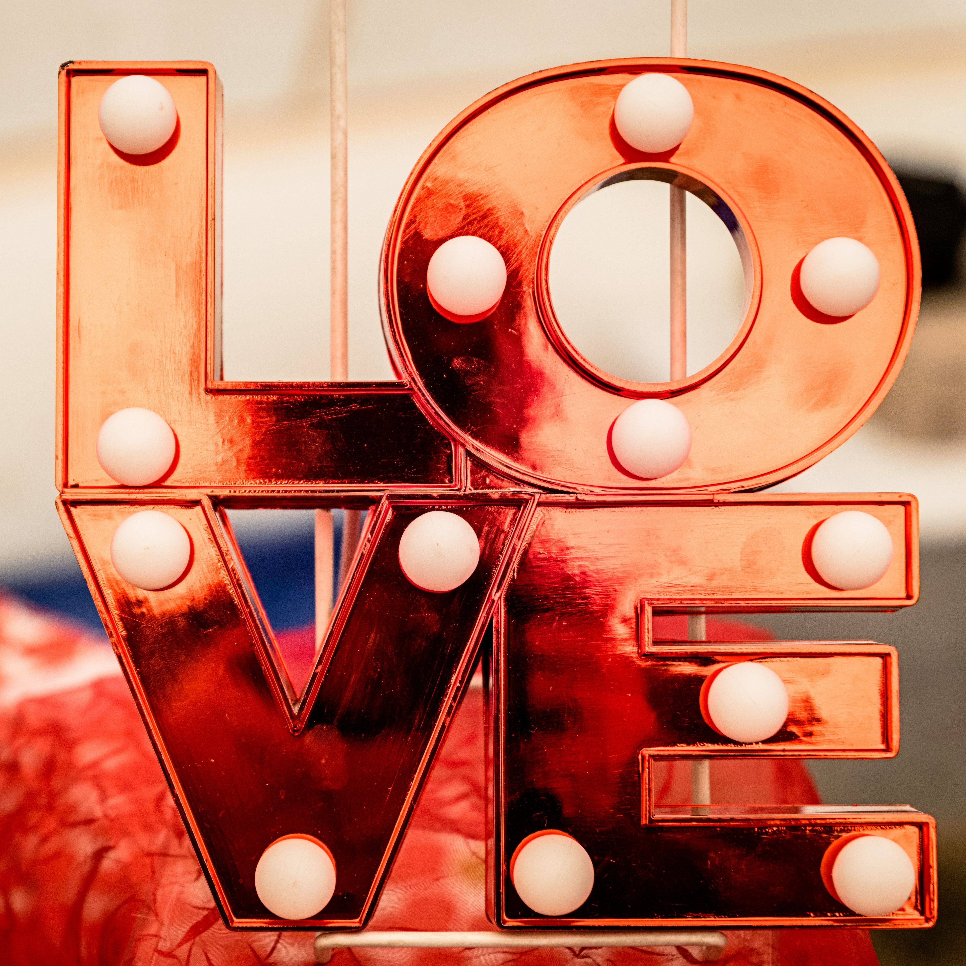 Red illuminated marquee sign spelling LOVE with white bulbs