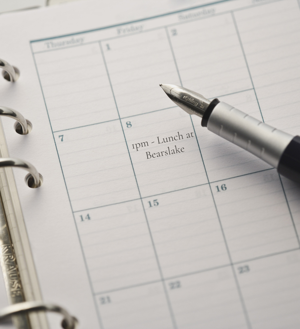 Fountain pen resting on a planner with a lunch appointment scheduled