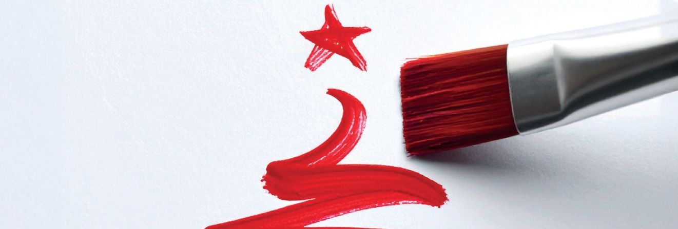 Red paintbrush painting a Christmas tree shape and star on white paper