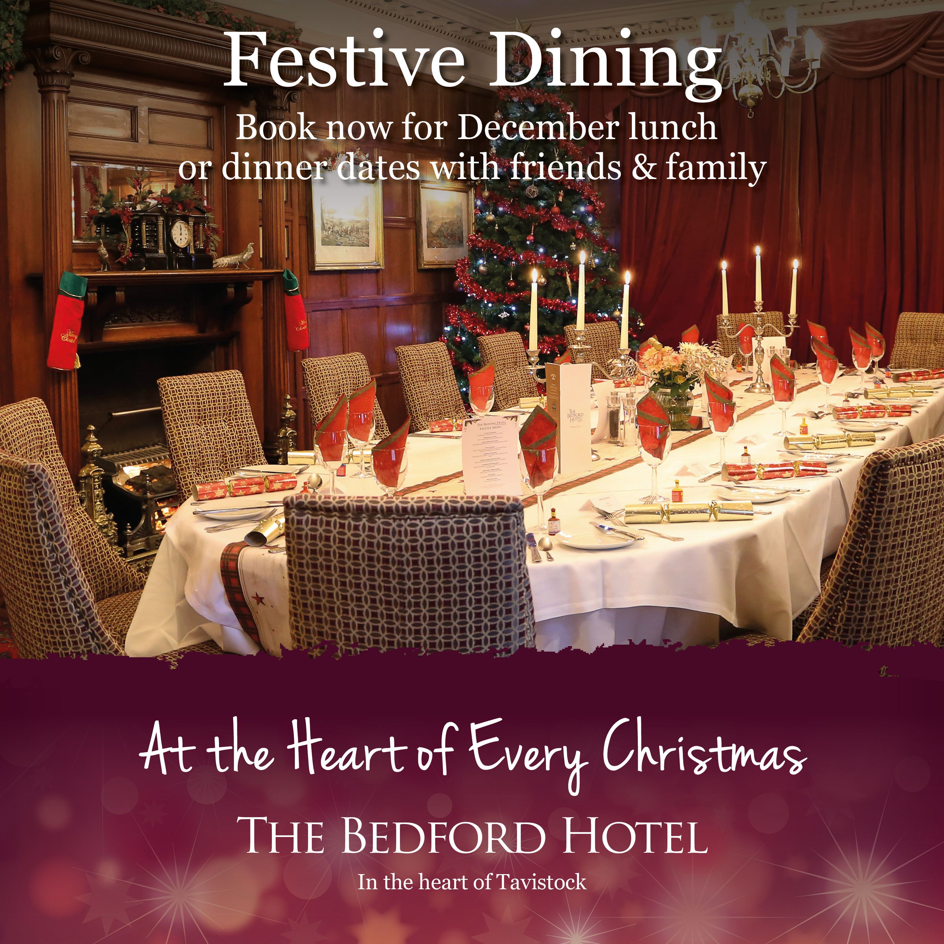 Festive dining table set for Christmas at The Bedford Hotel, decorated with Christmas crackers, red napkins, and a Christmas tree in the background.