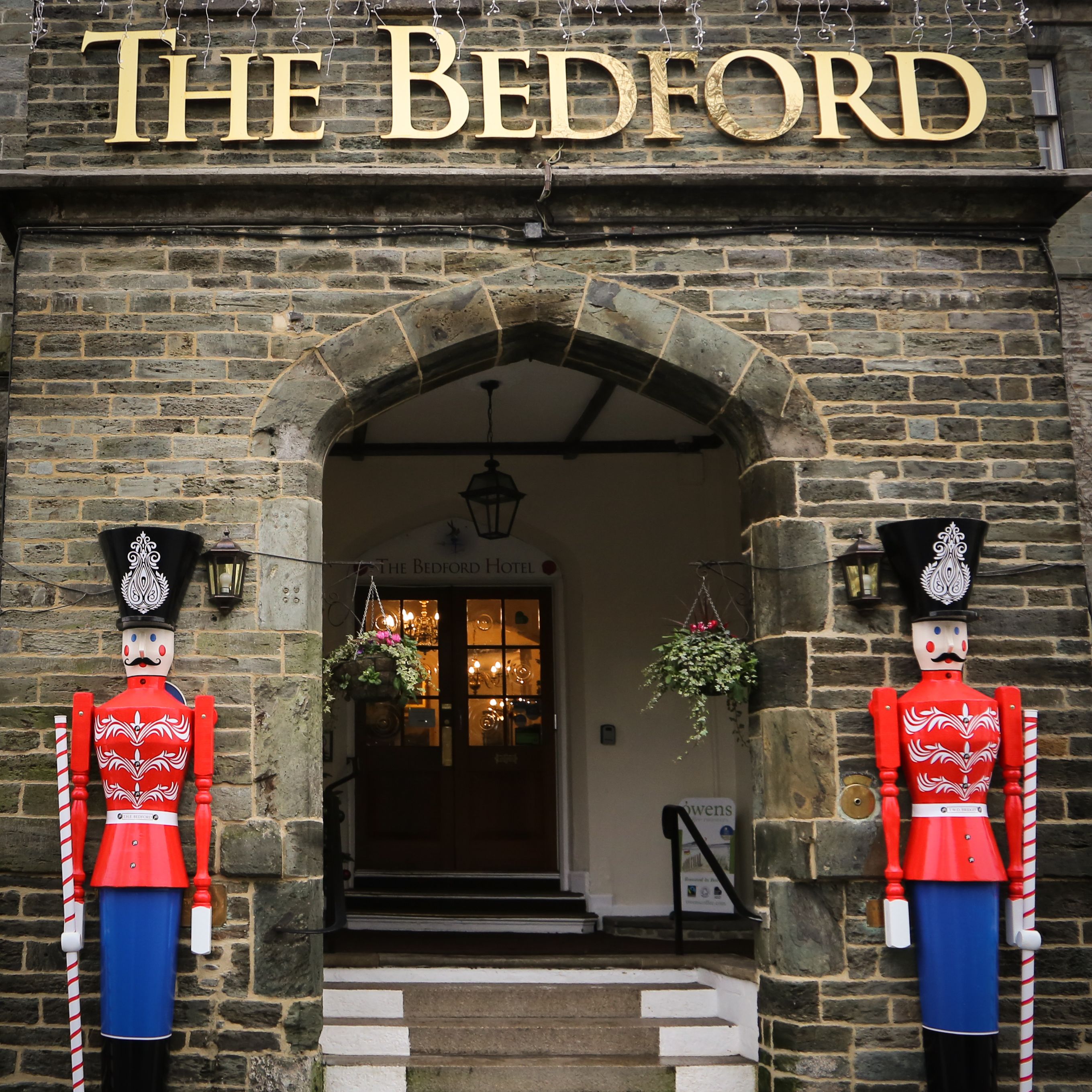 Entrance of The Bedford Hotel decorated with two large toy soldier figures for Christmas