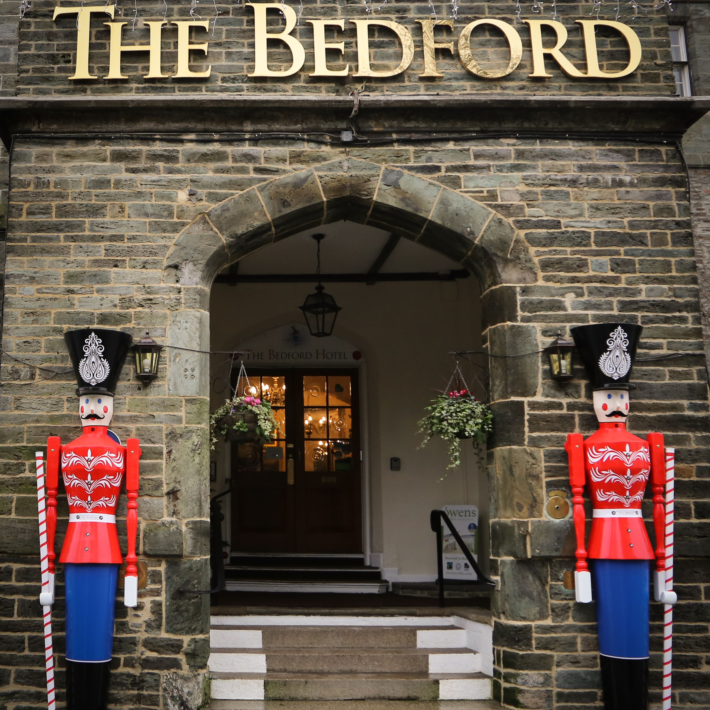 Entrance of The Bedford Hotel decorated with two large toy soldier figures for Christmas