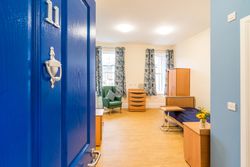 Bedroom with blue door and blue sheets on the bed