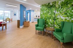 Living area with green chairs and tree wallpaper