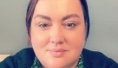 Woman with dark hair wearing a green patterned top and black cardigan, facing the camera