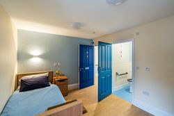 Bedroom with blue bedding and wet room