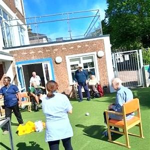 People participating in an outdoor activity in the garden area of a care facility.