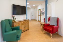 Red and green armchairs by tv in living area