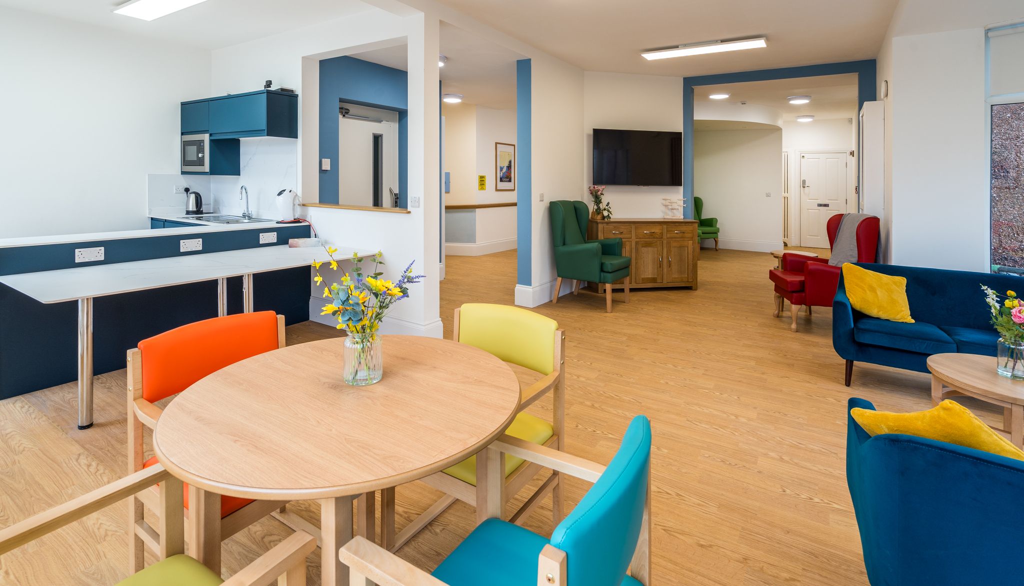 Living area with colourful chairs around tables