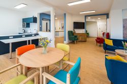 Living area with colourful chairs around tables