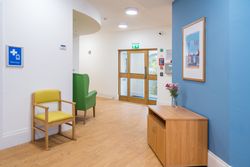 Hallway with yellow and green chairs and pictures on a blue wall