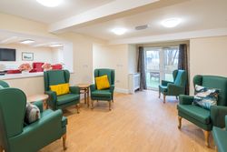 Green armchairs with yellow cushions in living area
