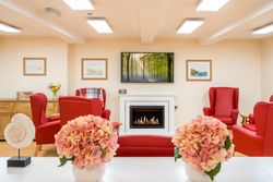 Living area with red arm chairs by fireplace