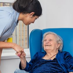 Nurse warmly greeting an elderly patient
