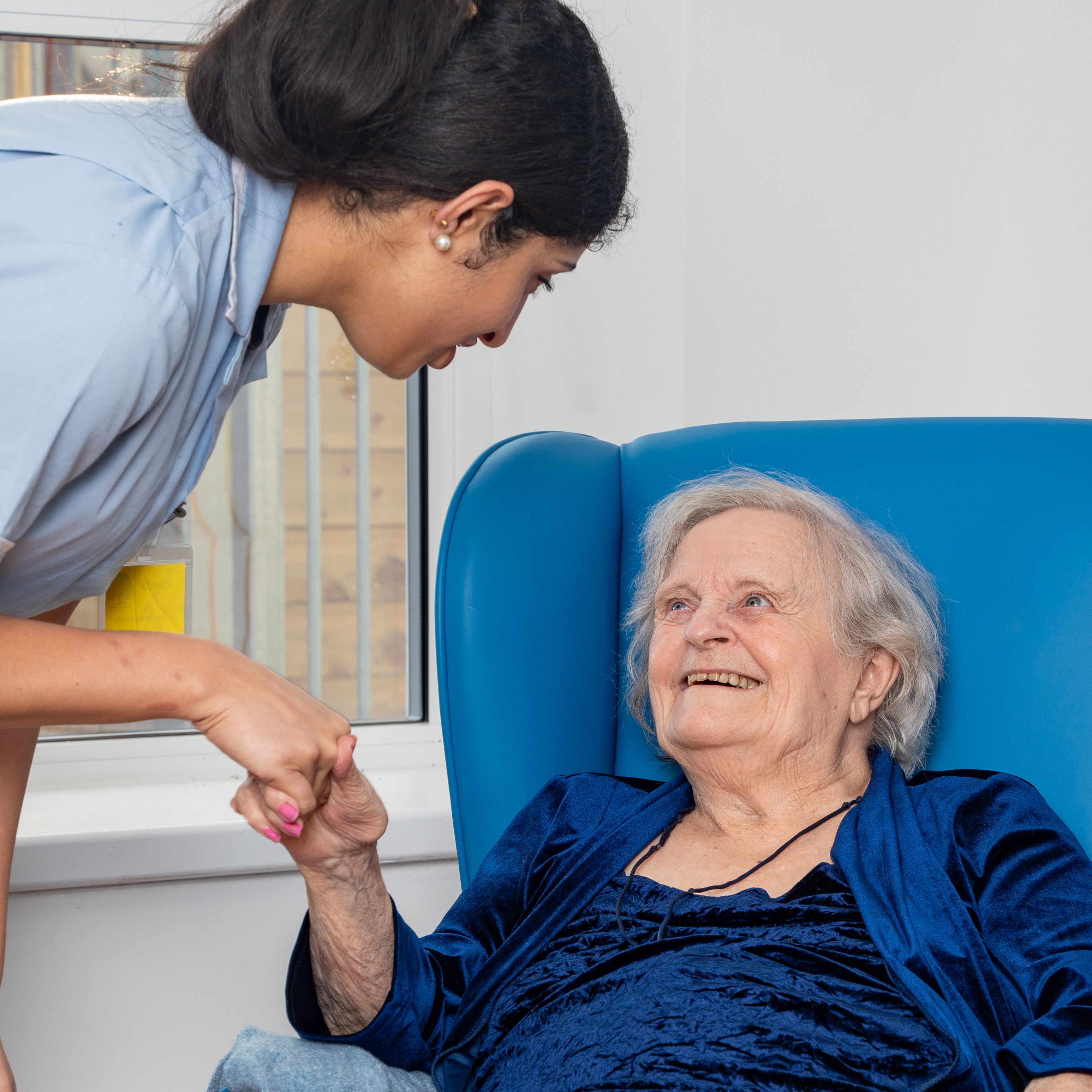 Nurse warmly greeting an elderly patient
