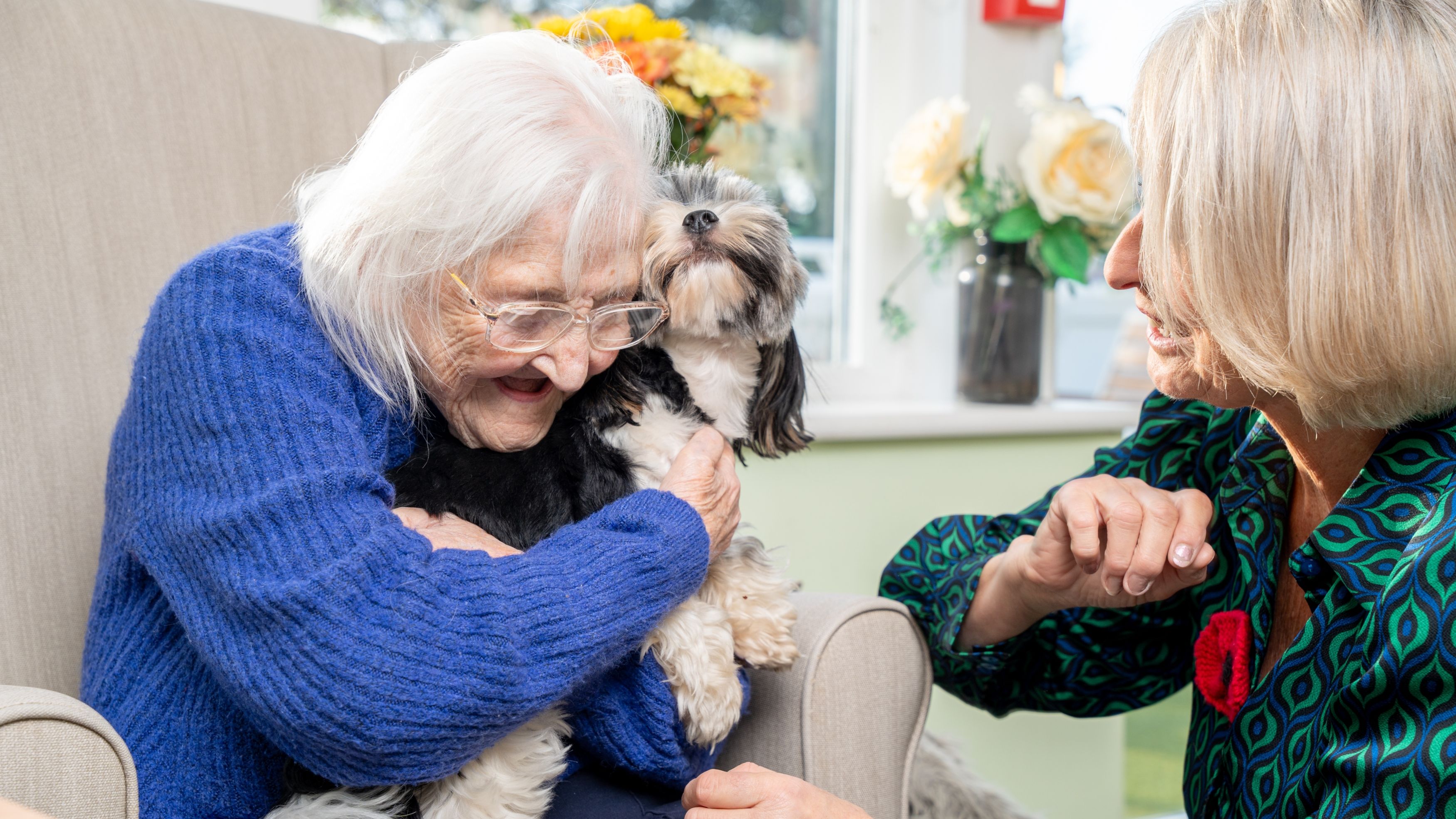 Elderly Woman Cuddling Small Dog