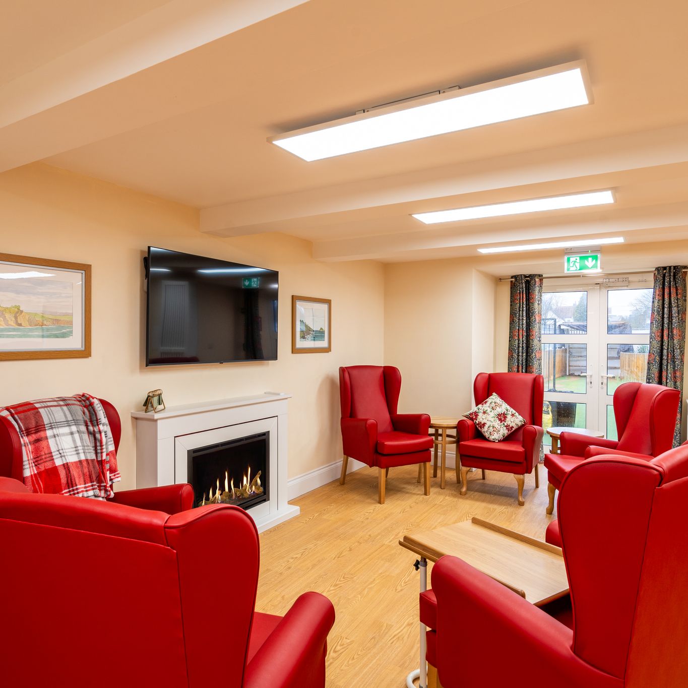 Living area with red armchairs by fireplace
