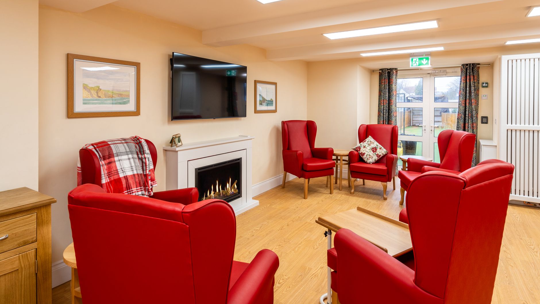 Living area with red armchairs by fireplace