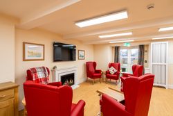 Living area with red armchairs by fireplace