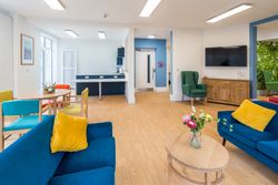 Living area with blue sofas and vase of flowers on table