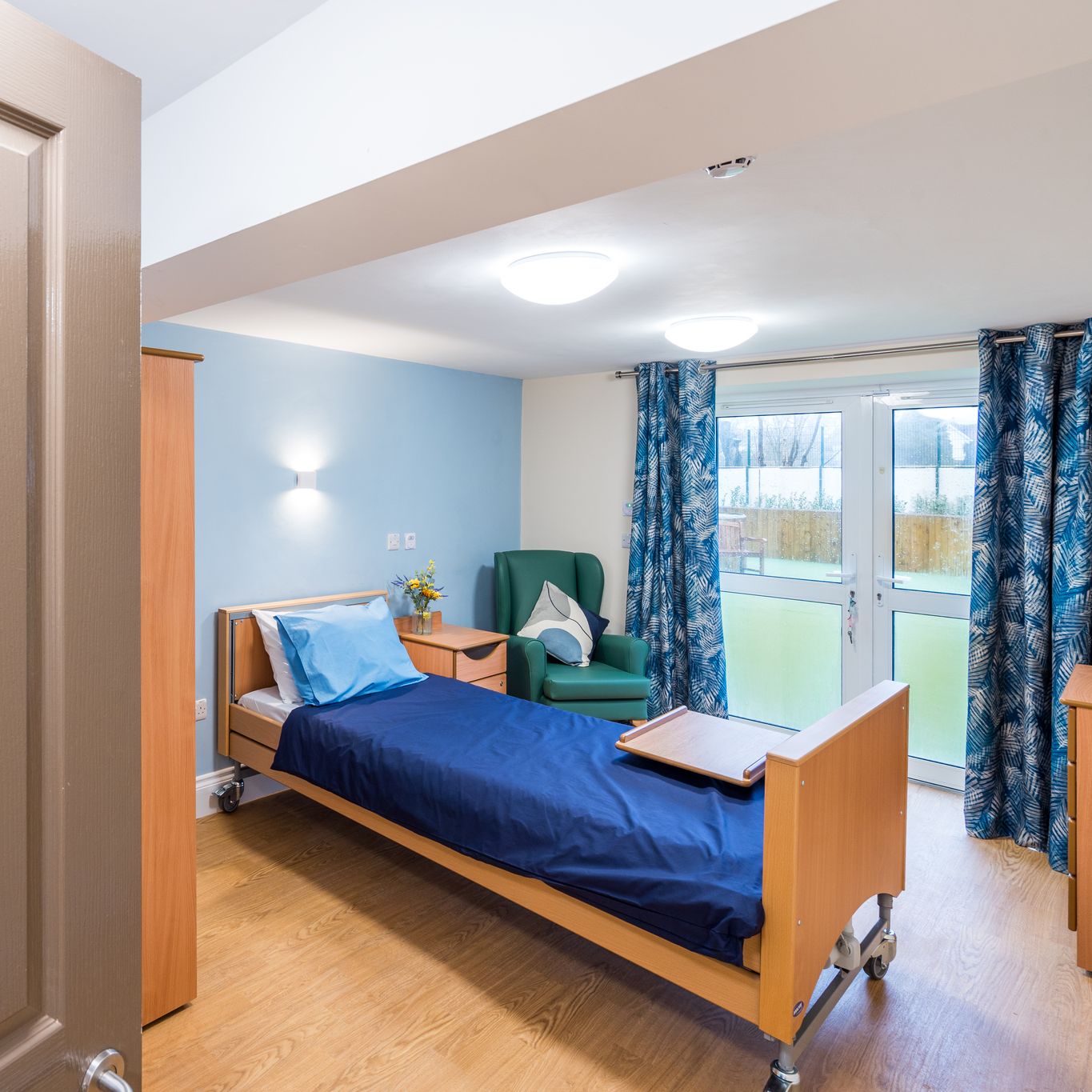 Bedroom with grey door and blue sheets on the bed