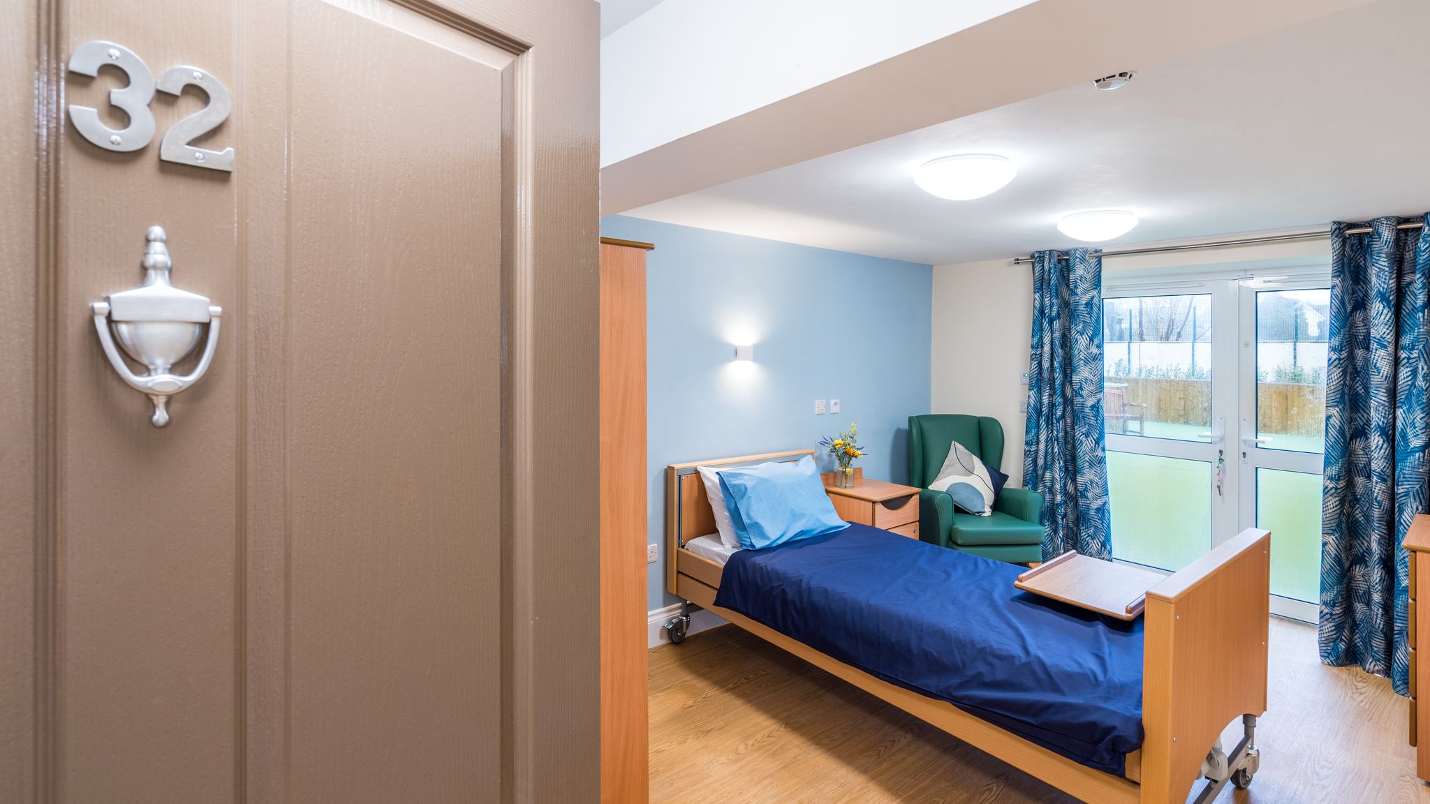 Bedroom with grey door and blue sheets on the bed
