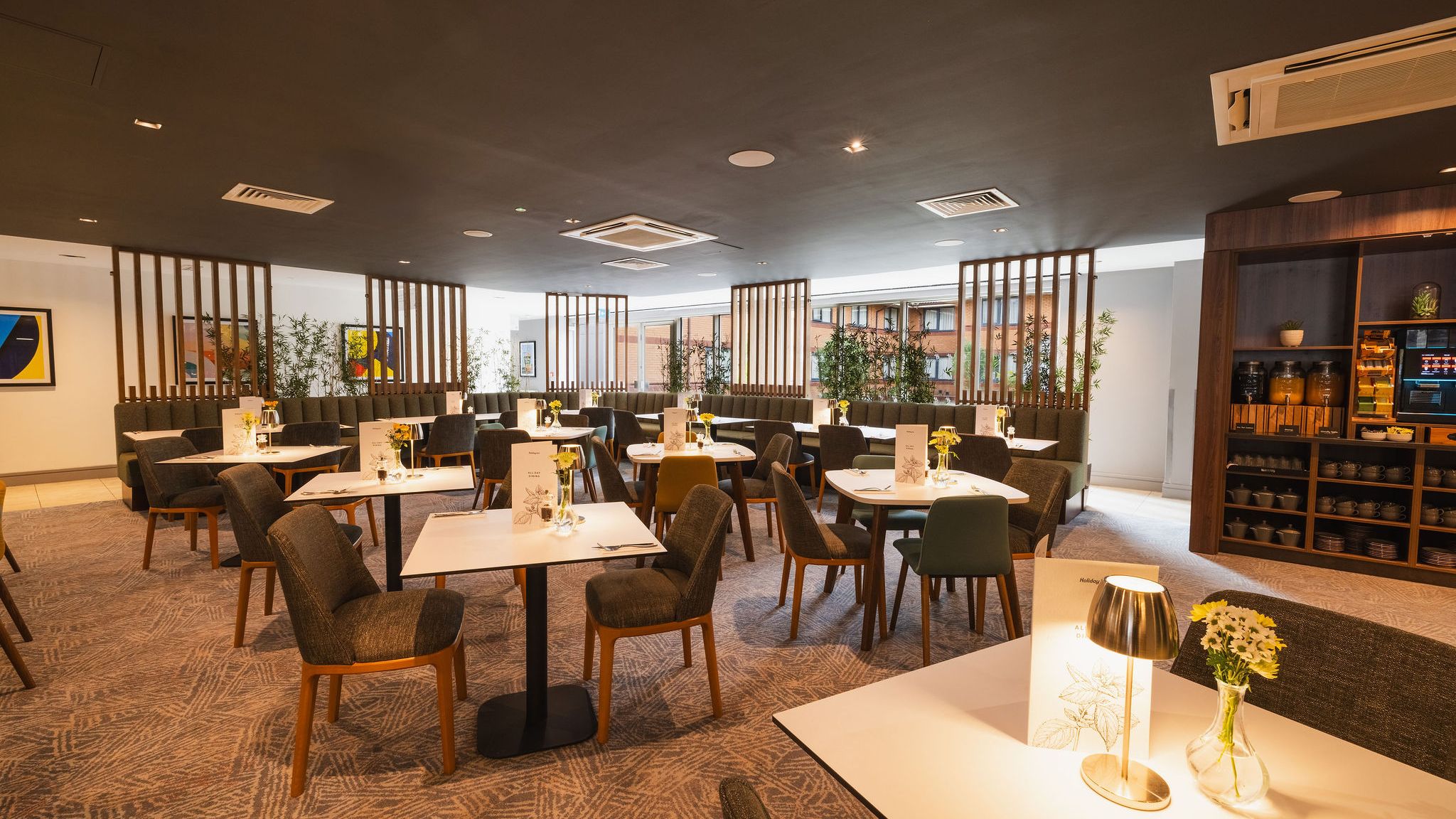 Modern hotel restaurant with neatly arranged tables, chairs, and decorative lighting