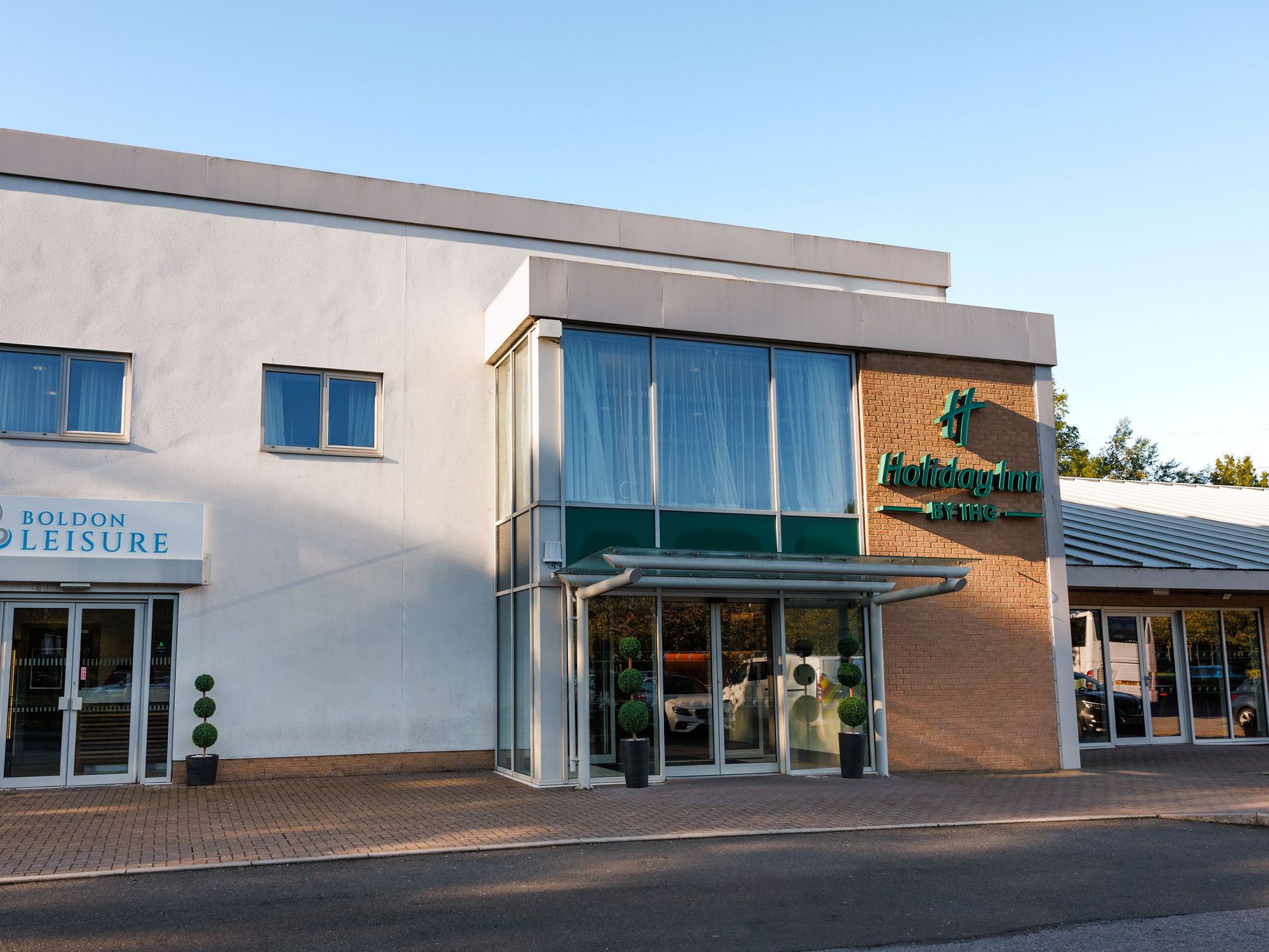 Entrance to Holiday Inn hotel and Boldon Leisure center with glass windows and potted plants