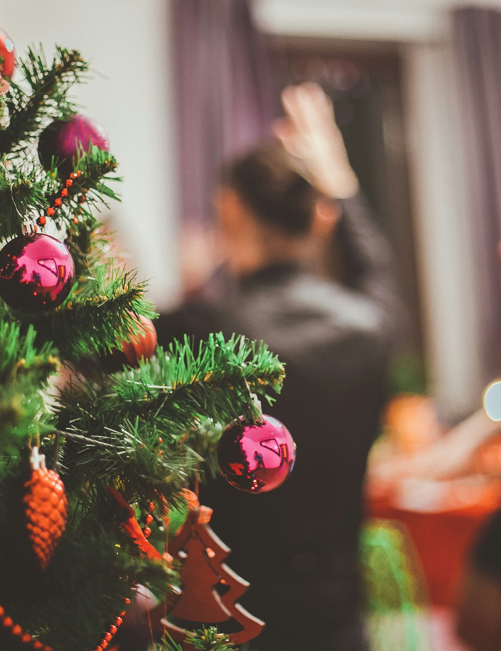 Close-up of a decorated Christmas tree with people blurred in the background