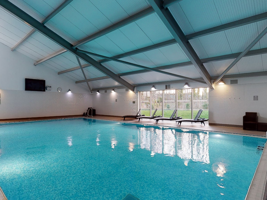 Indoor swimming pool with lounge chairs and large windows